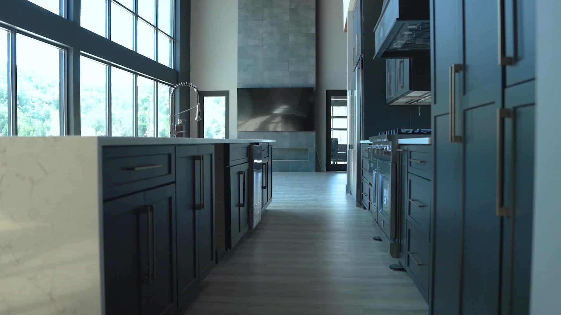 A modern kitchen in Knoxville features sleek black cabinetry, a natural stone countertop, stainless steel appliances, and large windows. The open space is filled with natural light, creating a bright and contemporary atmosphere.